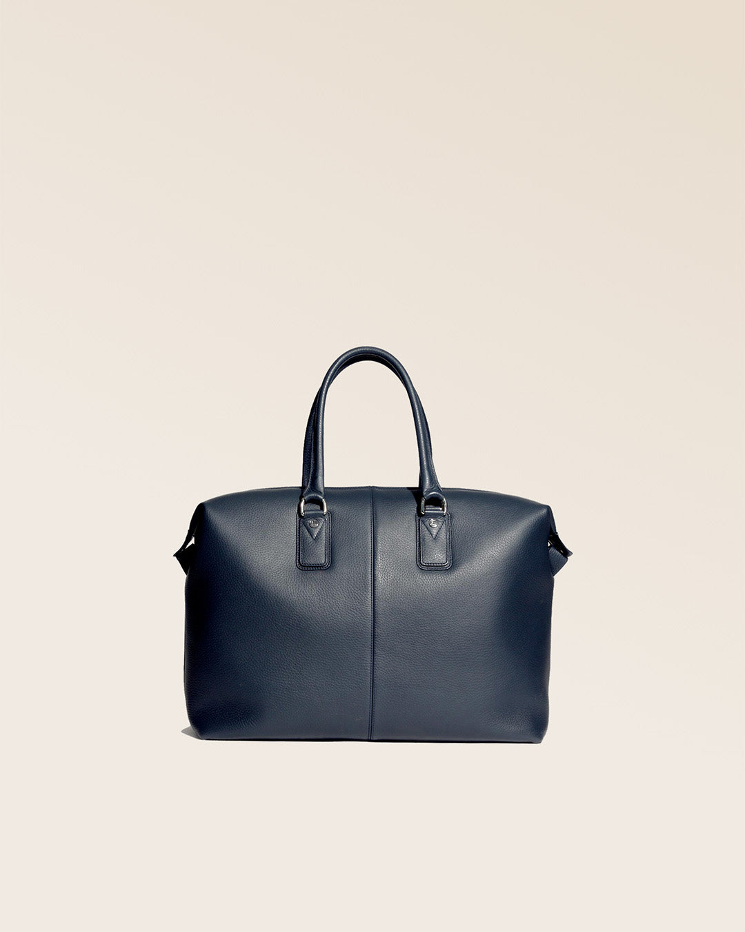 Notre sac de voyage Escapade petit modèle en cuir façon vigogne bleu marine vu de dos en studio. #taille_petit
