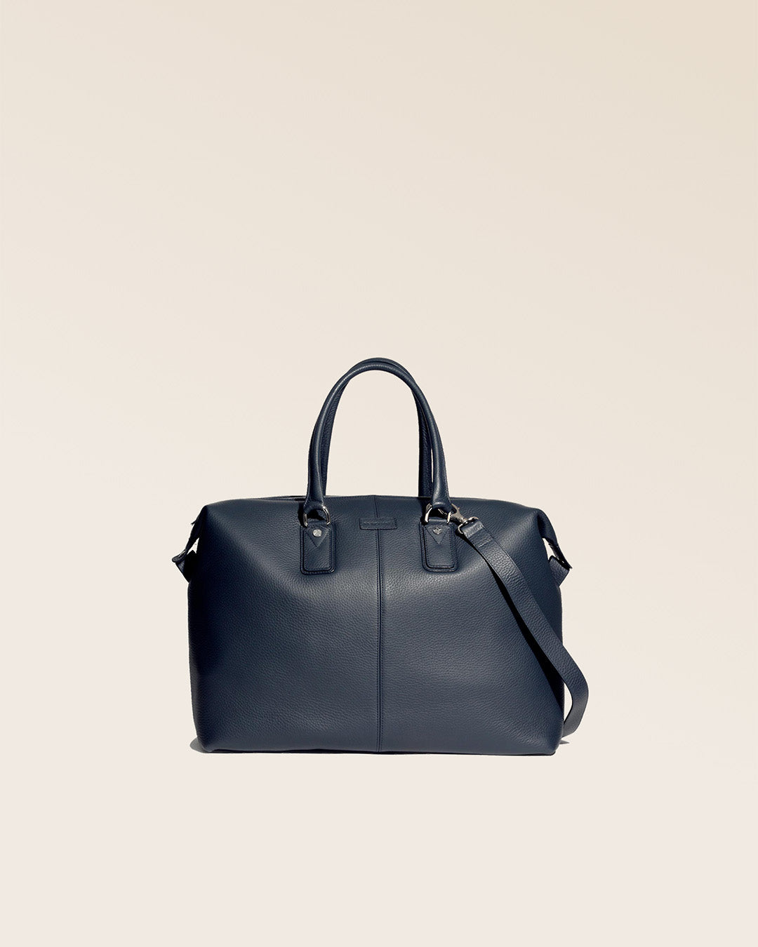 Notre sac de voyage Escapade petit modèle en cuir façon vigogne bleu marine vu de face en studio. #taille_petit