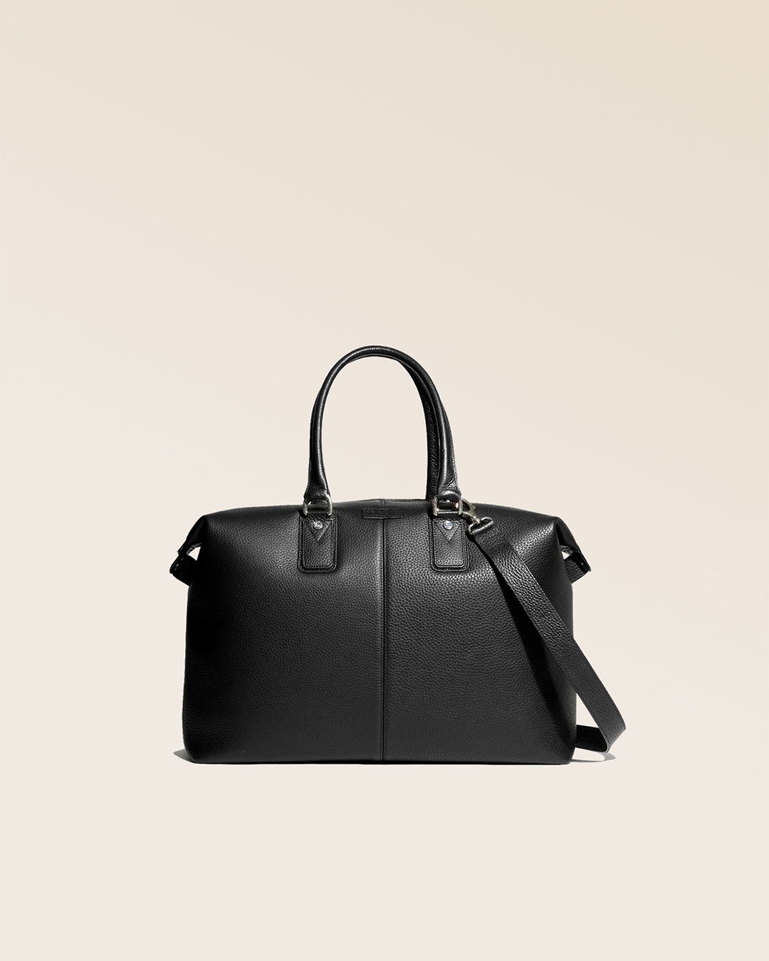 Notre sac de voyage Escapade petit modèle en cuir façon vigogne noir vu de face en studio.