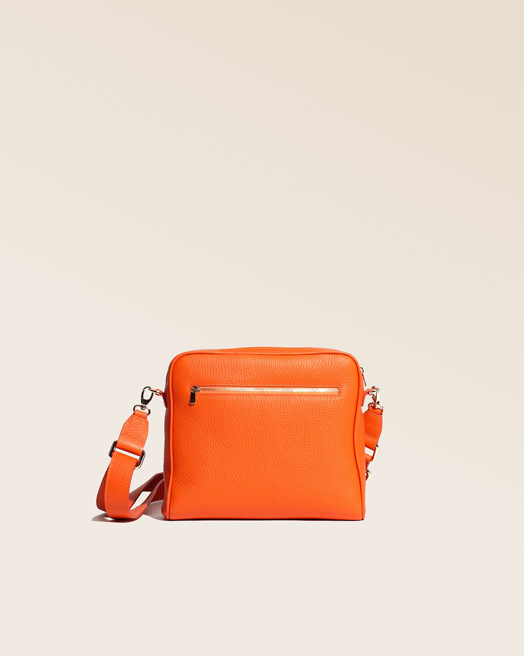 Our Zoom bag in orange vicuña-style leather with leather shoulder strap, seen from the back in the studio.