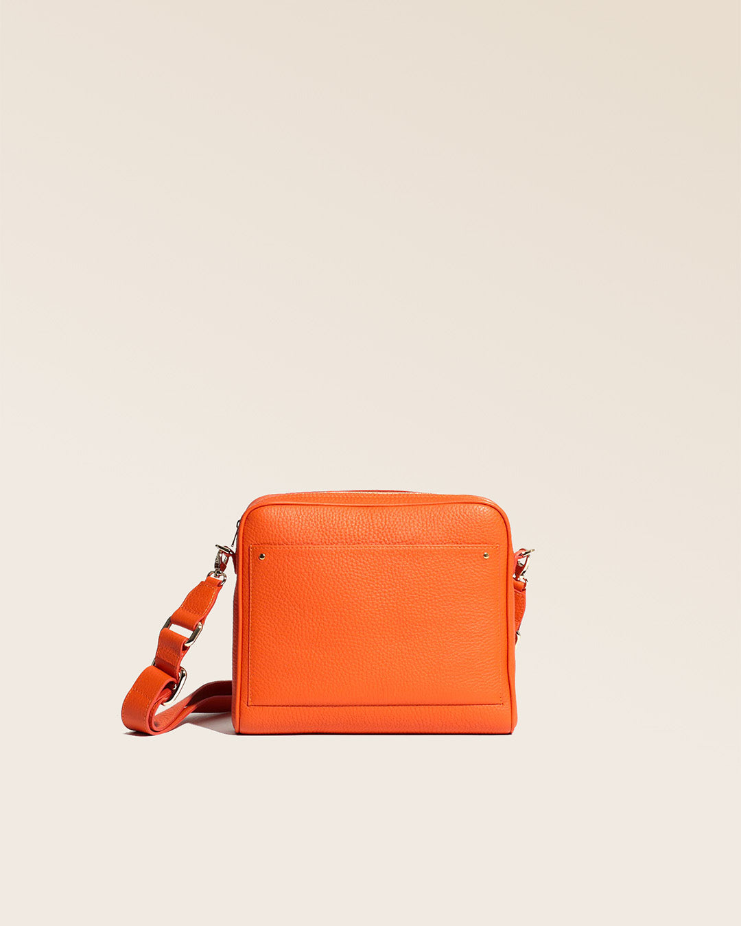Our Zoom bag in orange vicuña-style leather with leather shoulder strap, seen from the front in the studio.