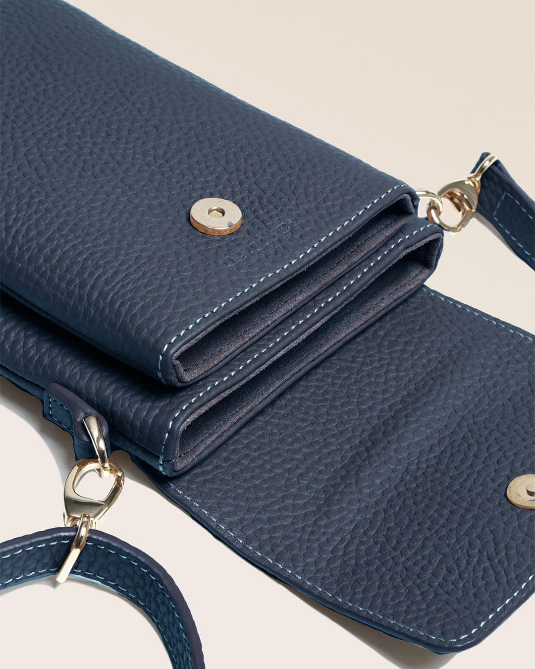 Our seagull clutch bag in navy blue vicuña-style leather, seen up close in the studio.