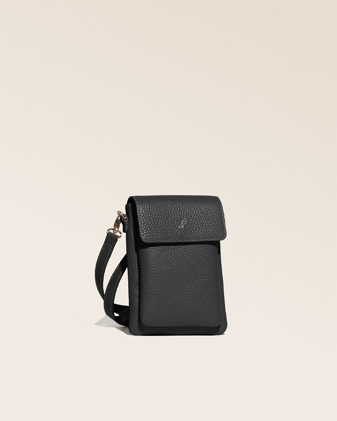 Our seagull clutch bag in black vicuña-style leather, seen from the quarter in the studio.