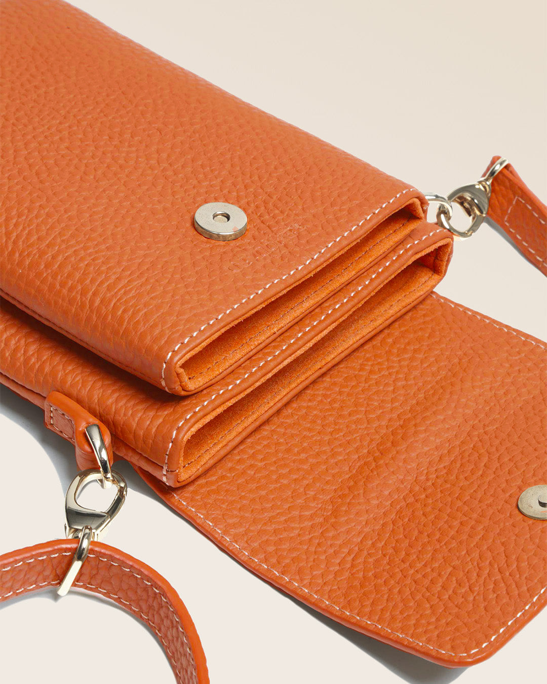 Our Gull clutch bag in orange vicuña-style leather, seen up close in the studio.