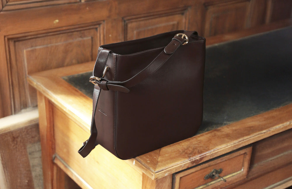 Découvrez l’élégance du cuir lisse ébène. Profonde et sophistiquée, sa teinte brun foncé sublime nos sacs, accessoires et chaussures avec une sobriété intemporelle.