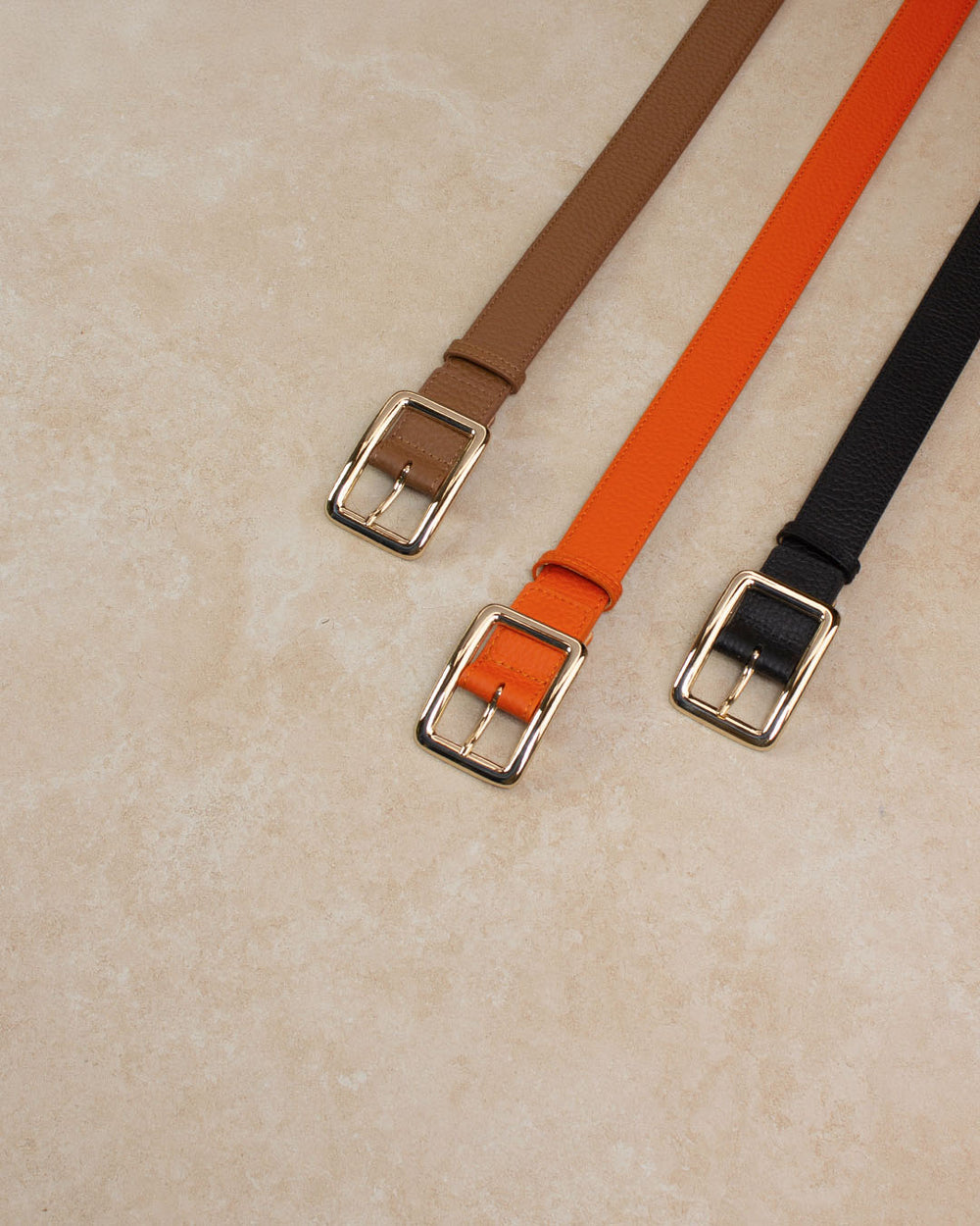Nos ceintures Ariane Renouard en cuir façon vigogne orange, fauve et noir vues en ambiance.