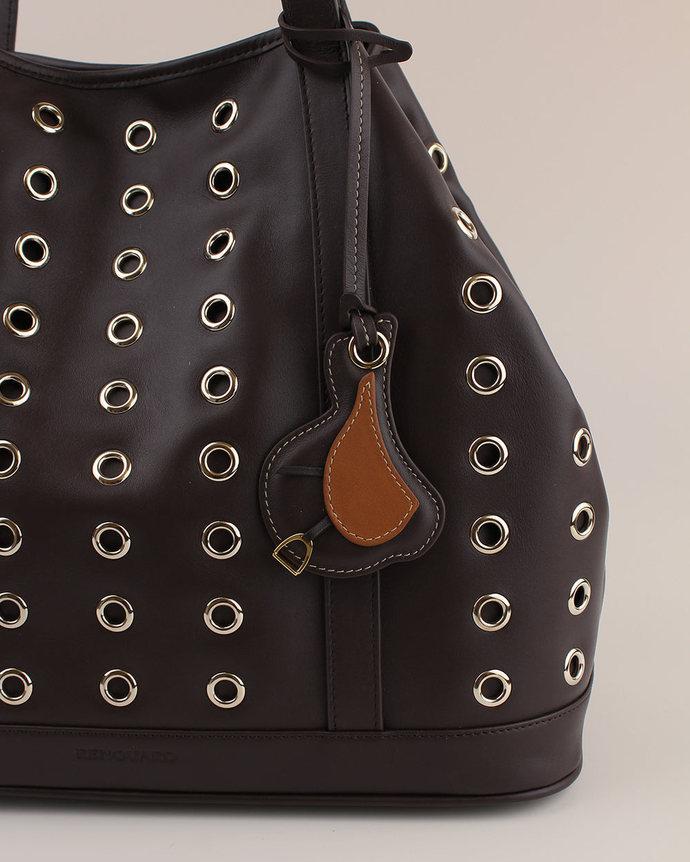 Le bijou de sac Selle Renouard en cuir lisse ébène et cuir lisse camel, vu sur notre sac Zanzibar en cuir lisse ébène.