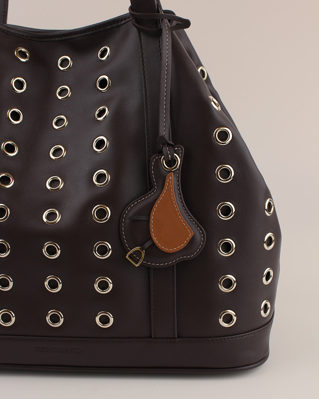 Le bijou de sac Selle Renouard en cuir lisse ébène et cuir lisse camel, vu sur notre sac Zanzibar en cuir lisse ébène.