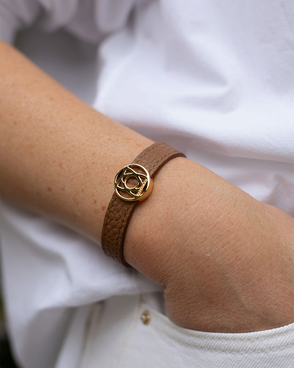 Le bracelet Alezan Renouard en cuir façon vigogne fauve et accessoire doré, vu porté. 