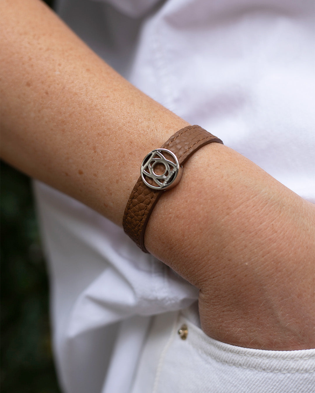Le bracelet Alezan Renouard en cuir façon vigogne fauve et accessoire nickelé, vu porté.