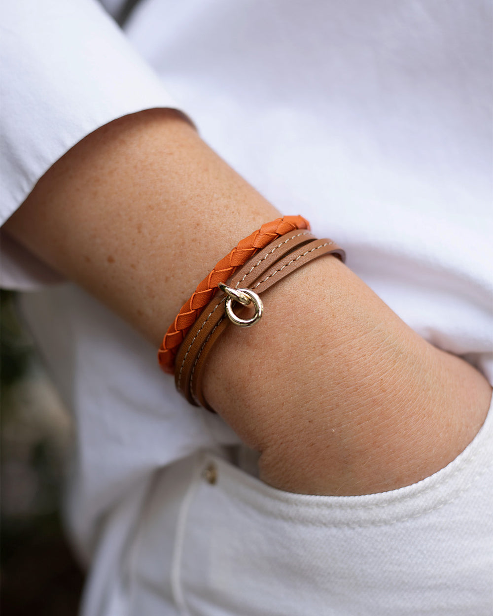 Notre bracelet Mohican en cuir d'agneau tressé orange et le bracelet Twin en cuir camel vu porté