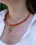 Notre collier Maillon doré en cuir vigogne orange, vue portée.