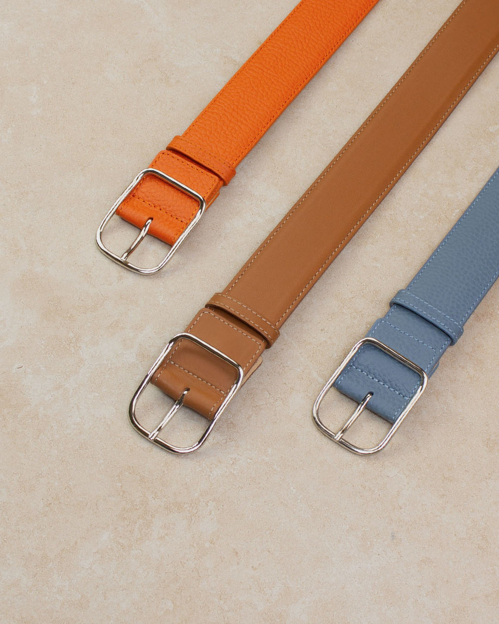 Nos ceintures James Renouard en cuir vintage camel,  orange et bleu cobalt vues en ambiance.