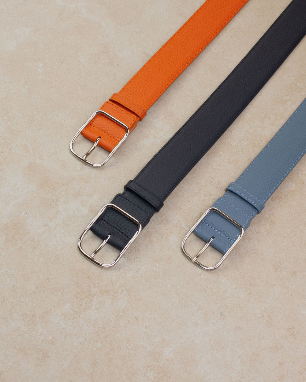 Nos ceintures James Renouard, en cuir façon vigogne bleu marine,  orange et bleu cobalt vues en ambiance.
