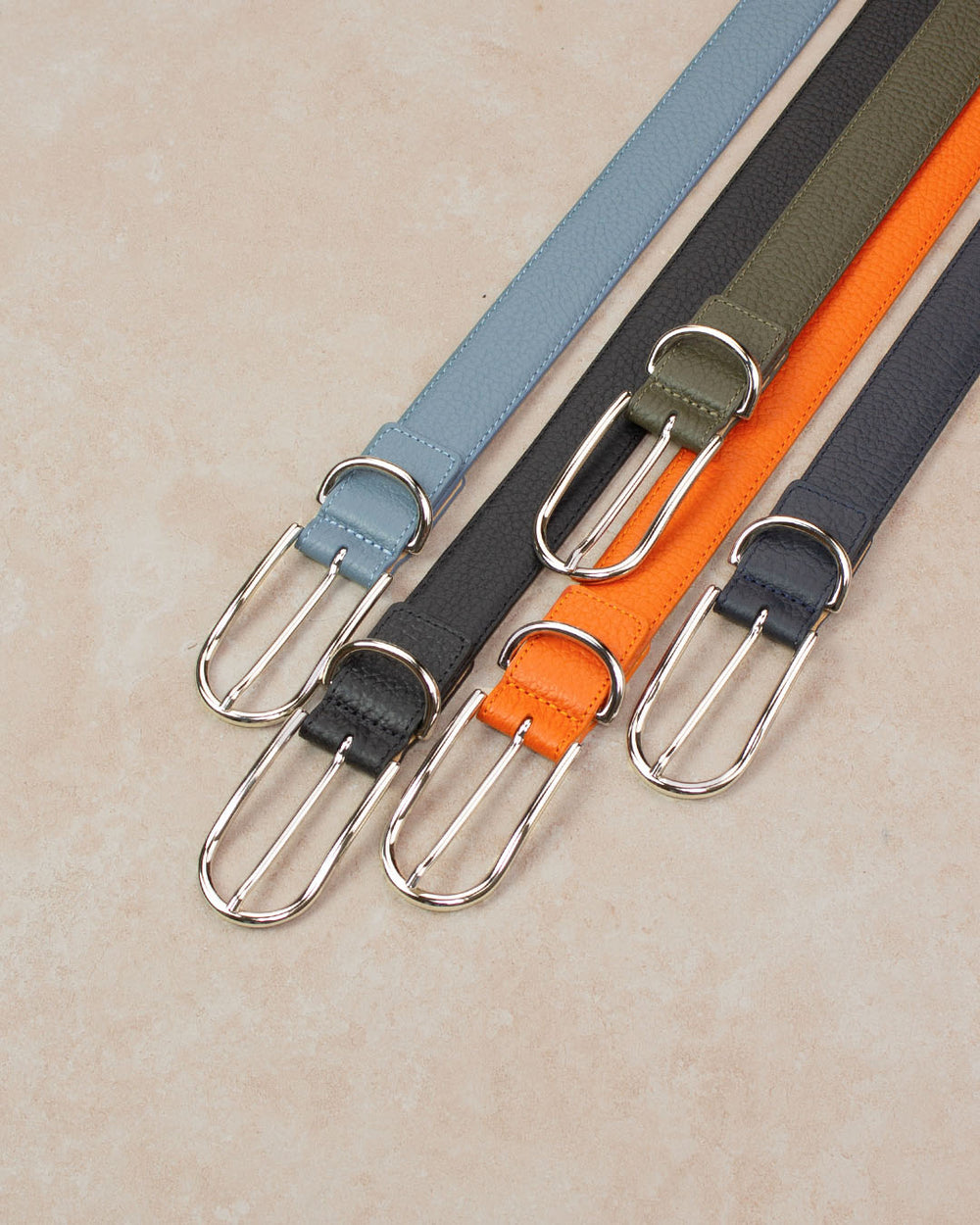 Nos ceintures Marina Renouard en cuir façon vigogne bleu cobalt, kaki, noir, marine, orange vues en ambiance.