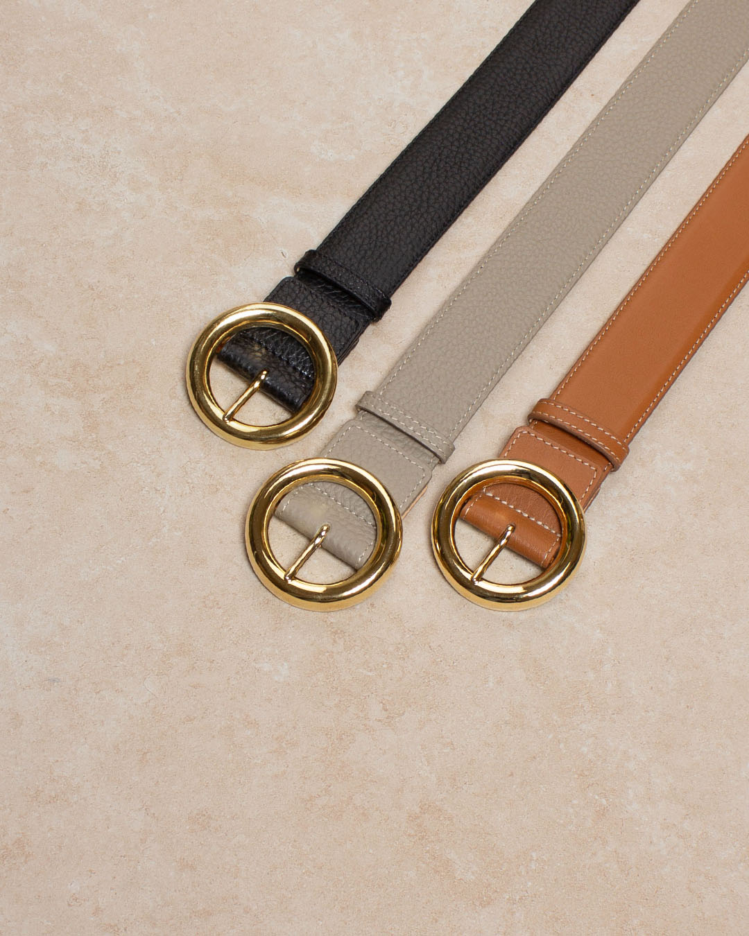 Notre ceinture Tamara Renouard en cuir vintage camel et en cuir vigogne corde, noir avec une boucle dorée, vue en ambiance.