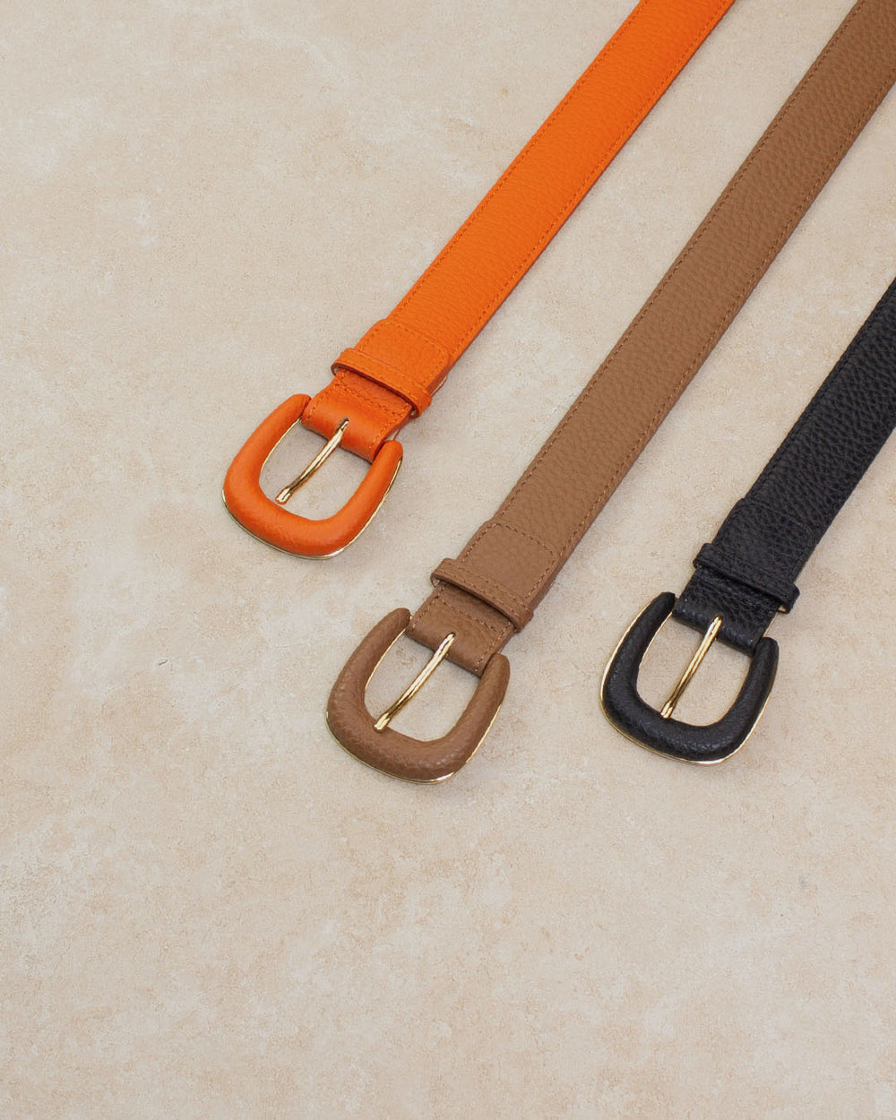Nos ceintures Zoé Renouard en cuir vigogne fauve, orange et noir vues en ambiance.