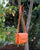 Le sac Sofia Renouard en cuir façon vigogne orange, vu en ambiance.