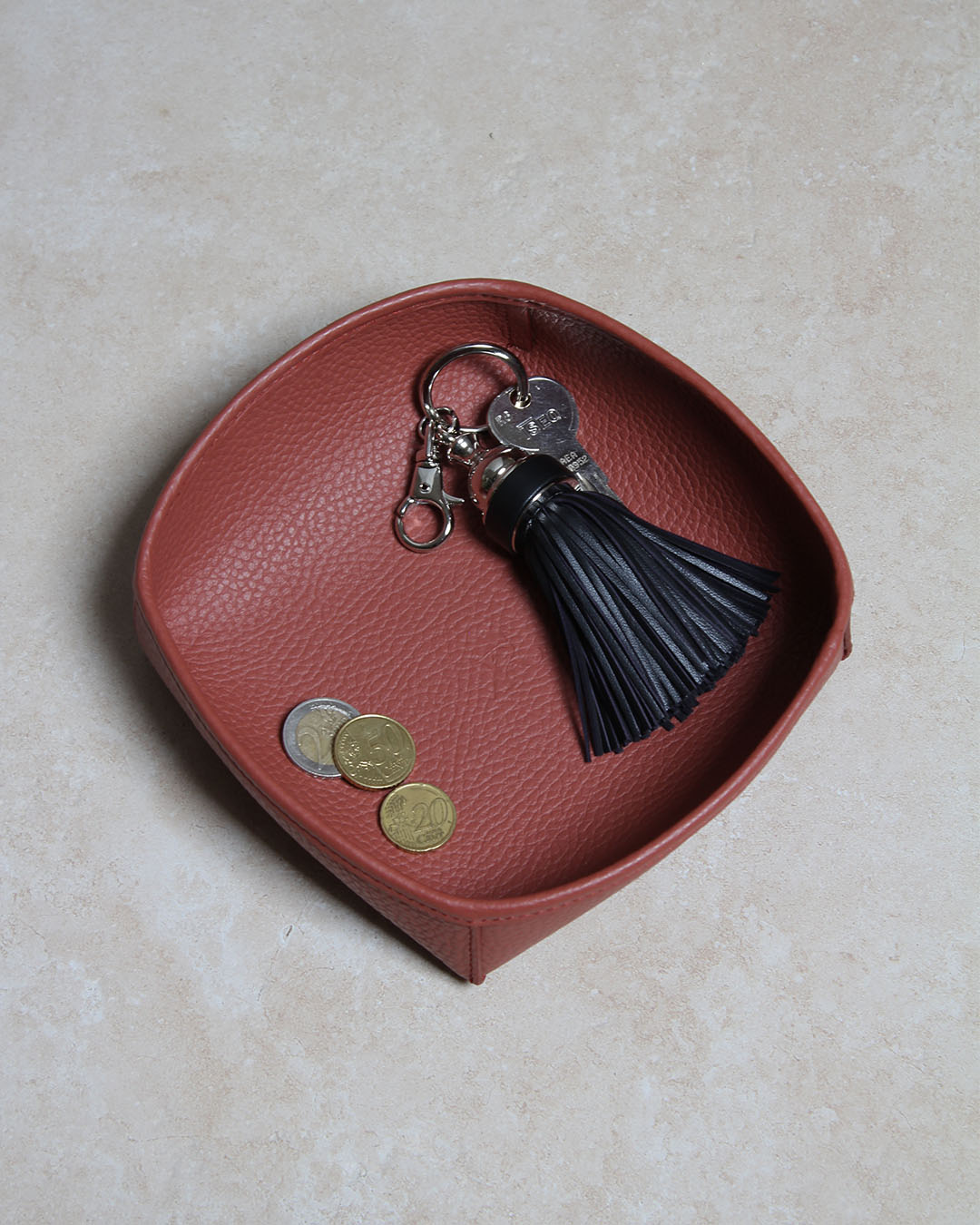 Notre porte-clé Madrid Renouard en cuir noir, vue en ambiance dans notre vide-poche kiwi en cuir vigogne terracotta.