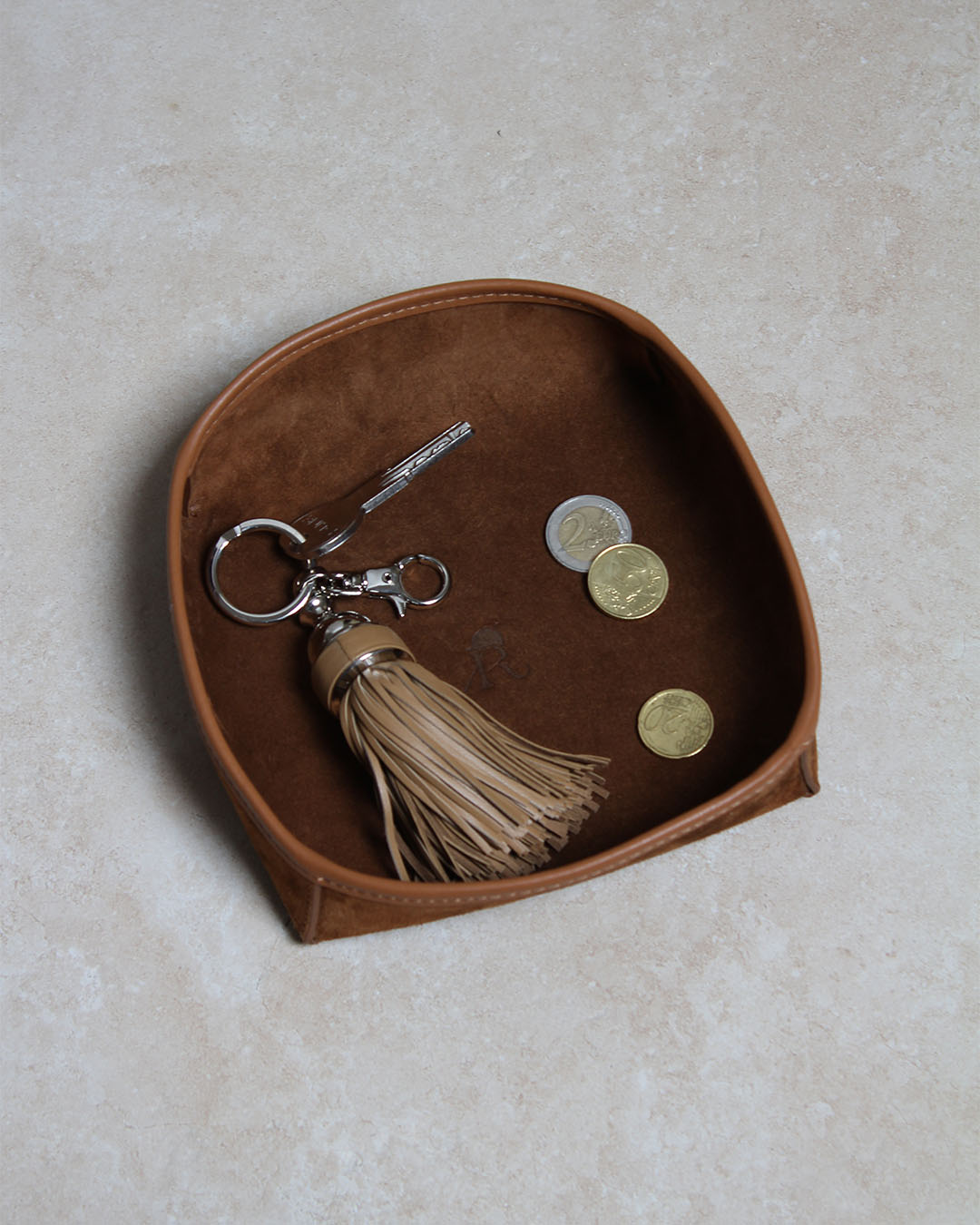 Notre porte-clé Madrid Renouard en cuir camel, vu en ambiance dans notre vide-poche kiwi  en cuir velours noisette.