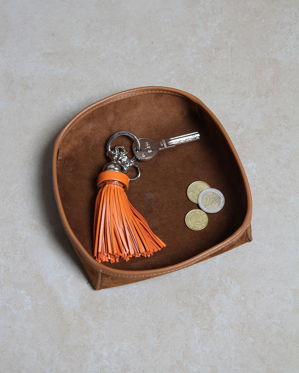 Le porte-clés Madrid Renouard en cuir orange, vu en ambiance dans notre vide-poche kiwi en cuir veau velours noisette.