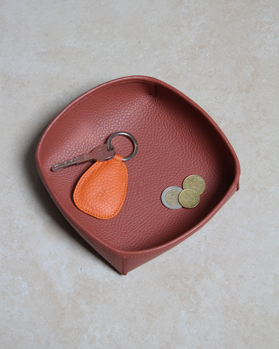 Notre porte-clé Anneau Renouard en cuir vigogne orange, vue en ambiance dans notre vide-poche kiwi en cuir vigogne terracotta