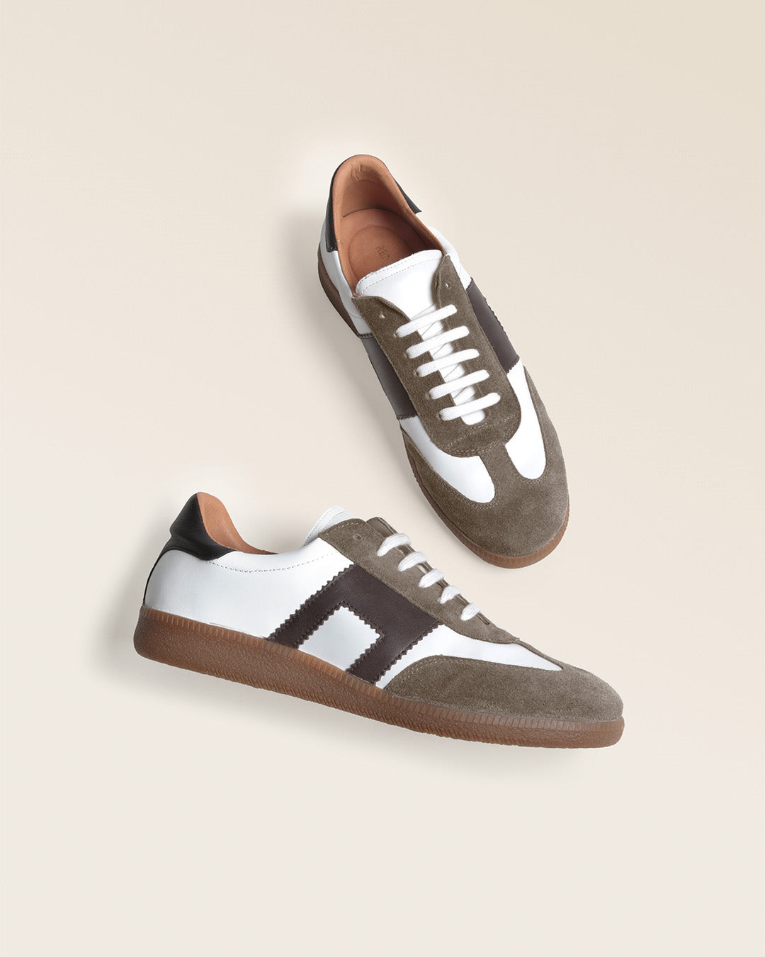 Nos sneakers Lucas Renouard pour homme en cuir lisse craie et chocolat surmontées d'un velours taupe, vues en studio.