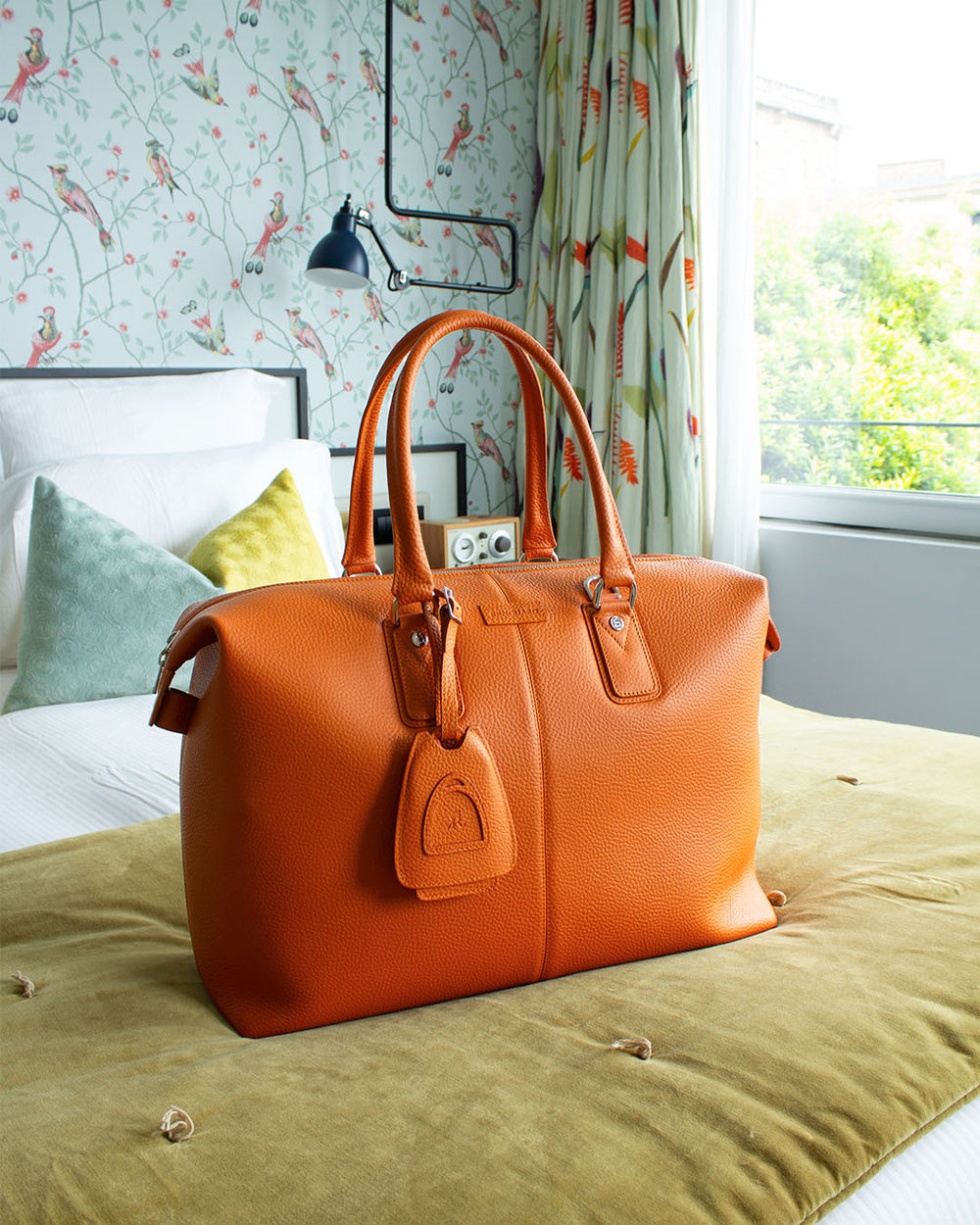 Notre sac Escapade Renouard dans sa version petit modèle, en cuir façon vigogne orange, vu en ambiance.