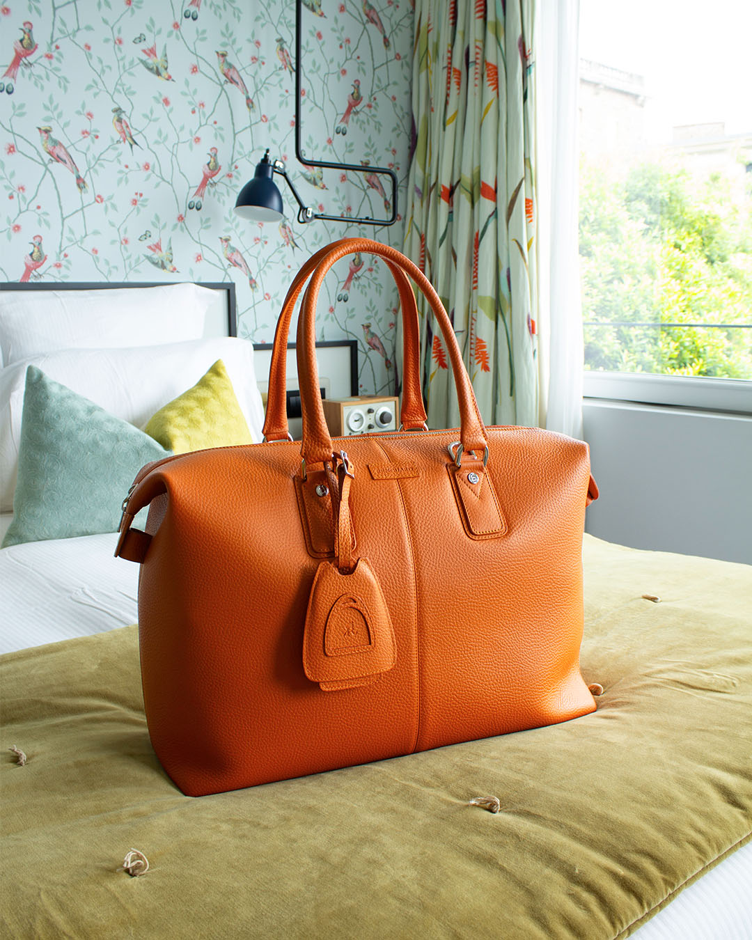 Notre sac Escapade Renouard dans sa version petit modèle, en cuir façon vigogne orange, vu en ambiance.