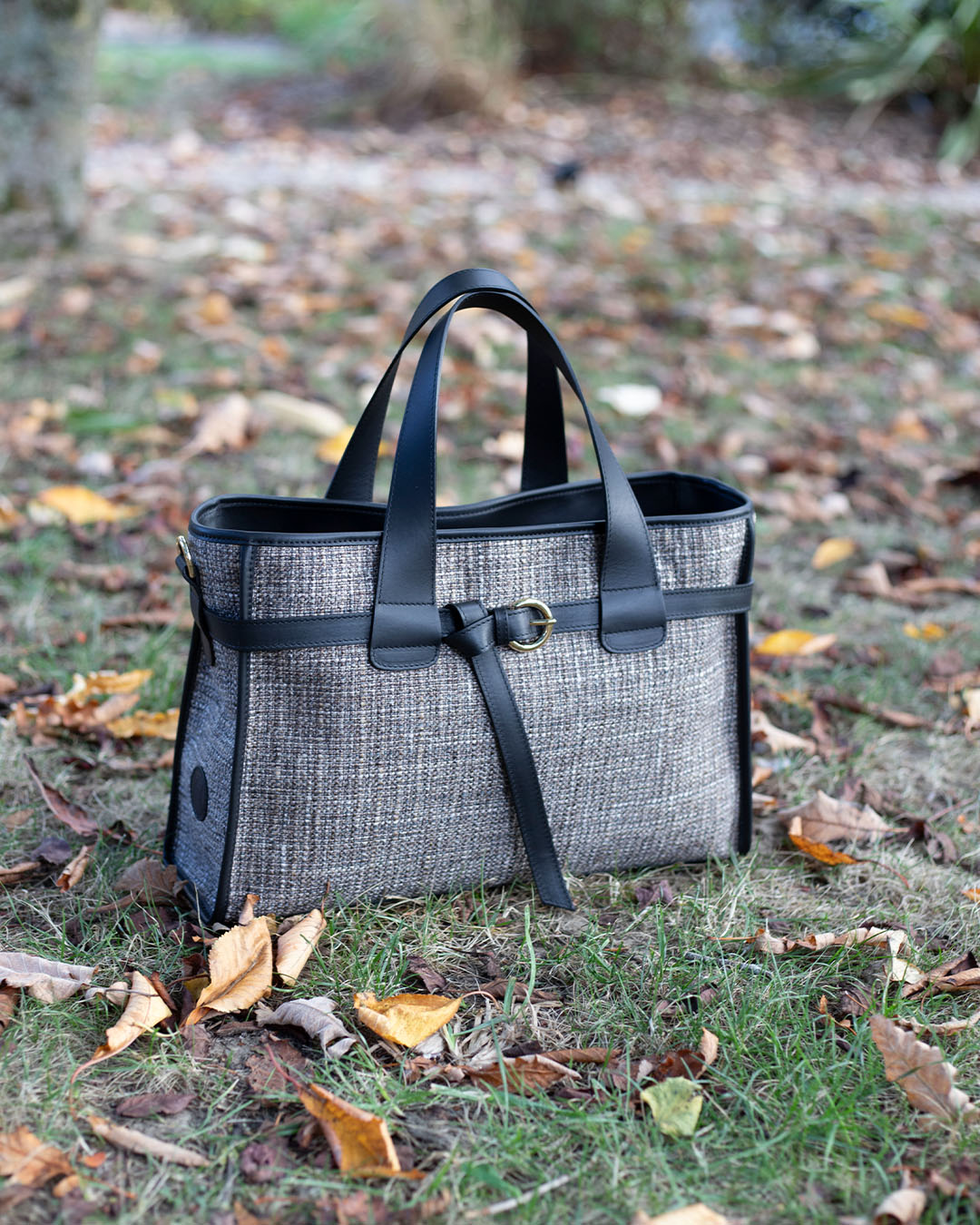 Le sac Constance Renouard en toile tweed taupe et cuir lisse noir, vu de quart en ambiance.
