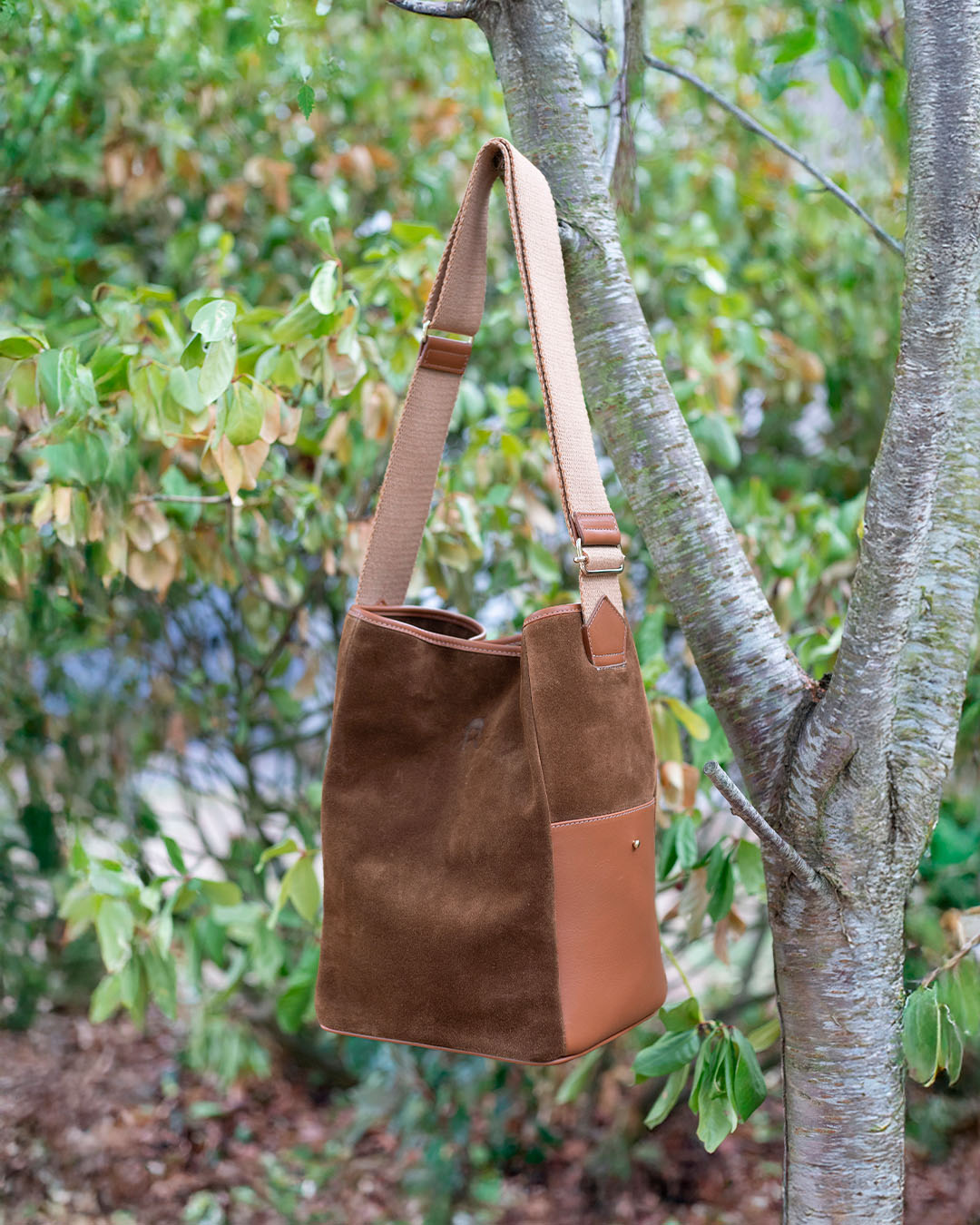 Le sac Gaspard Renouard en cuir veau velours noisette et lisse camel, vu en ambiance.