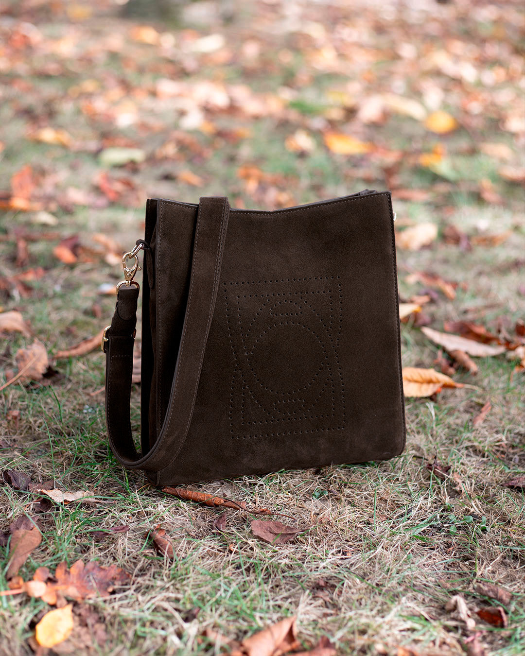 Le sac Mini Étrivière Renouard en cuir veau espresso, vu de quart en ambiance.