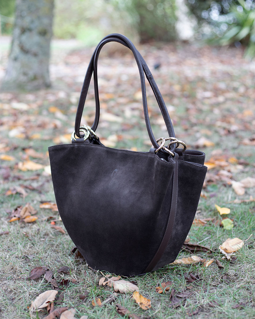 Le sac Païta Renouard en cuir veau velours espresso et lisse ébène, vu de quart en ambiance.