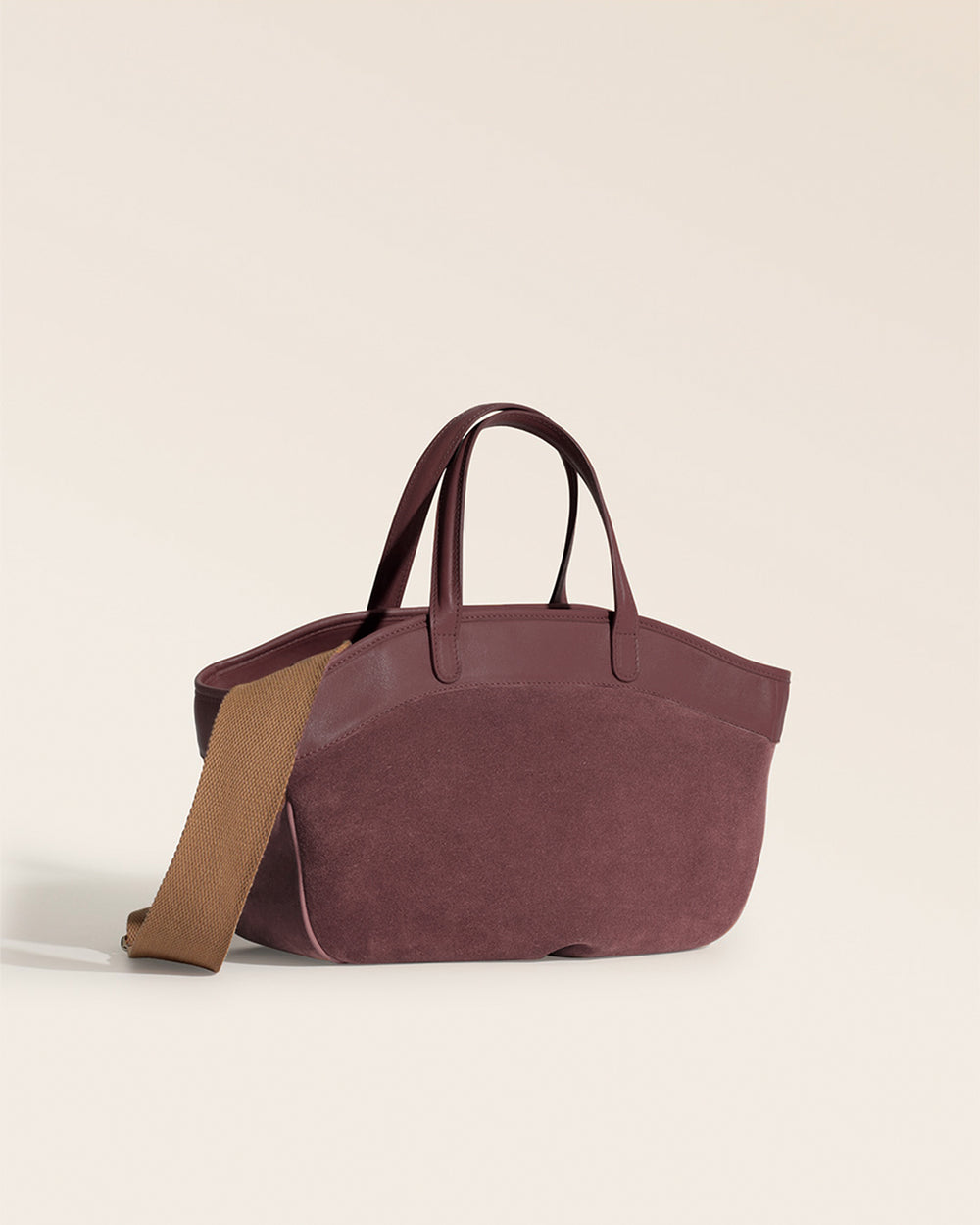 Le sac Sarah Renouard en cuir veau velours acajou et lisse acajou, avec sa bandoulière coton camel, vu de quart en studio.