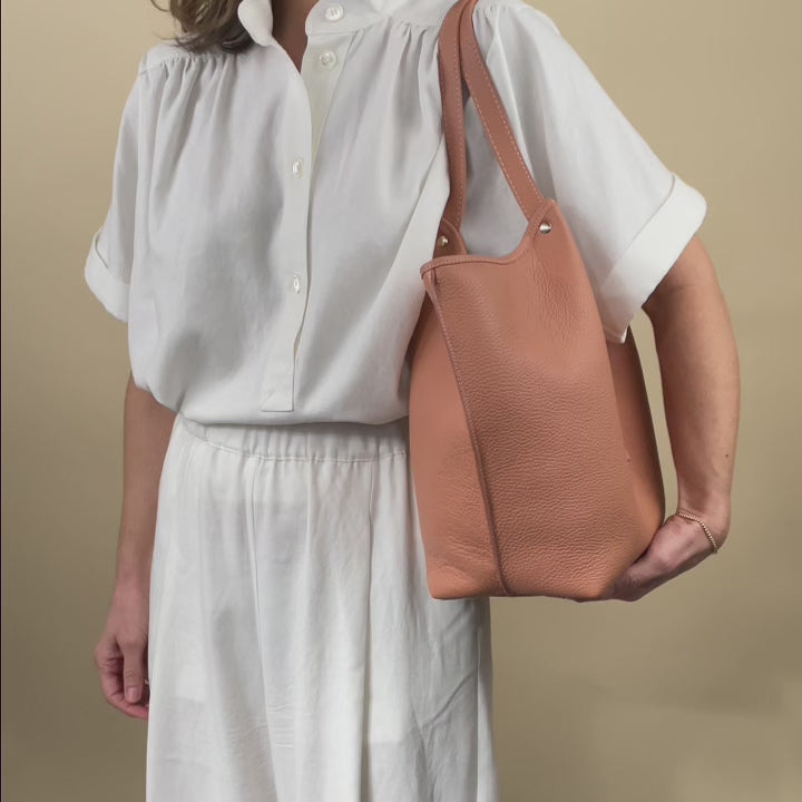 Notre sac Hunter Renouard en cuir façon vigogne pêche, vu porté en studio.