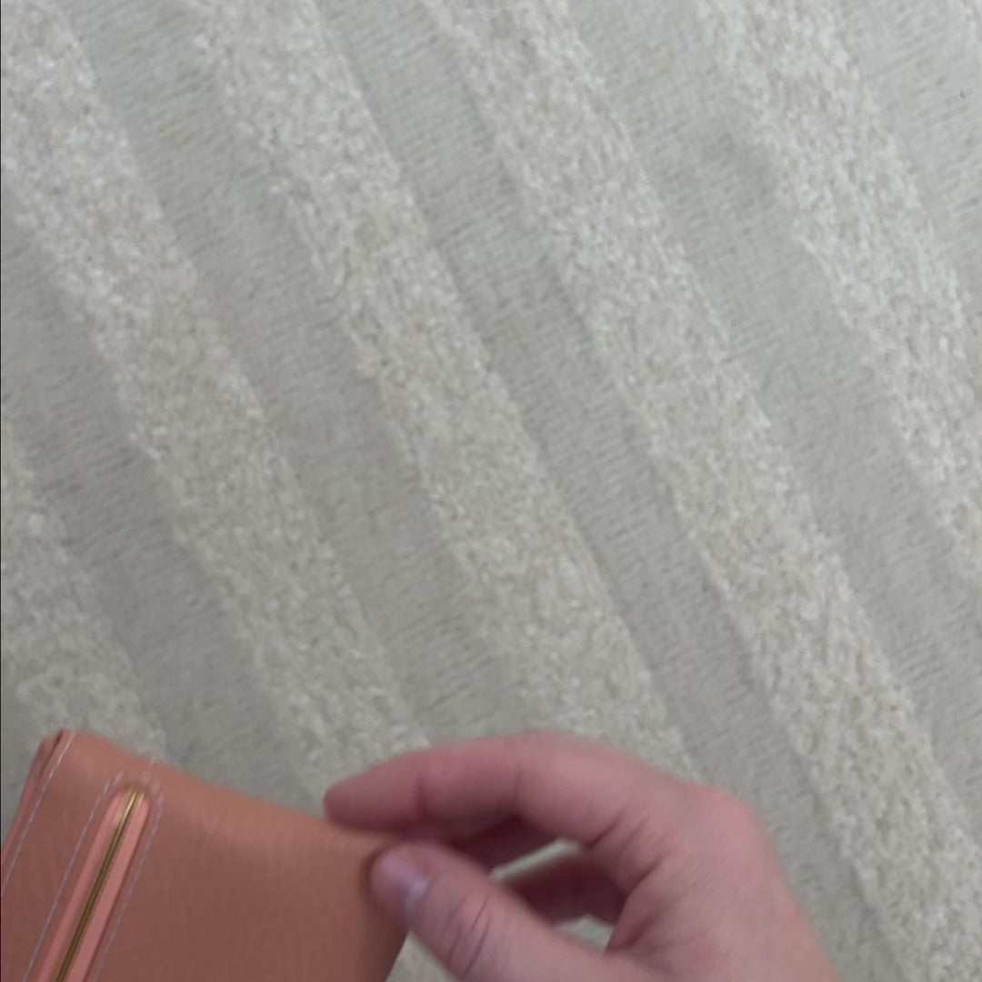 Notre porte-monnaie Capucine Renouard en cuir façon vigogne pêche, vu en studio. 