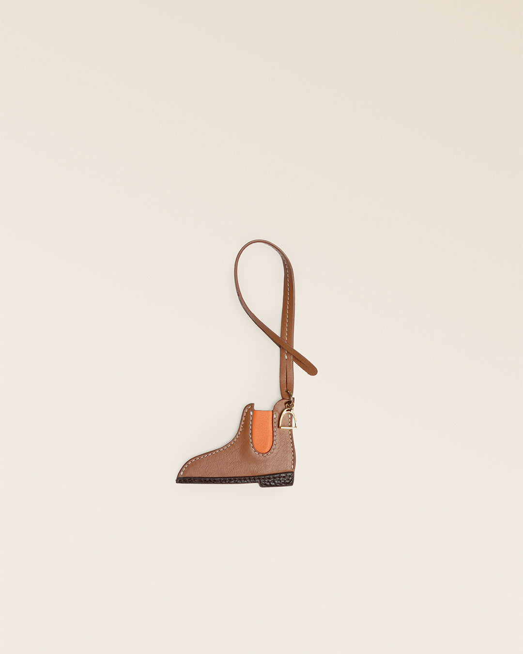 Le bijou de sac Boots Renouard en cuir lisse camel et détails orange et chocolat, parfait pour accessoiriser votre sac ou cabas Renouard cet automne ! 
