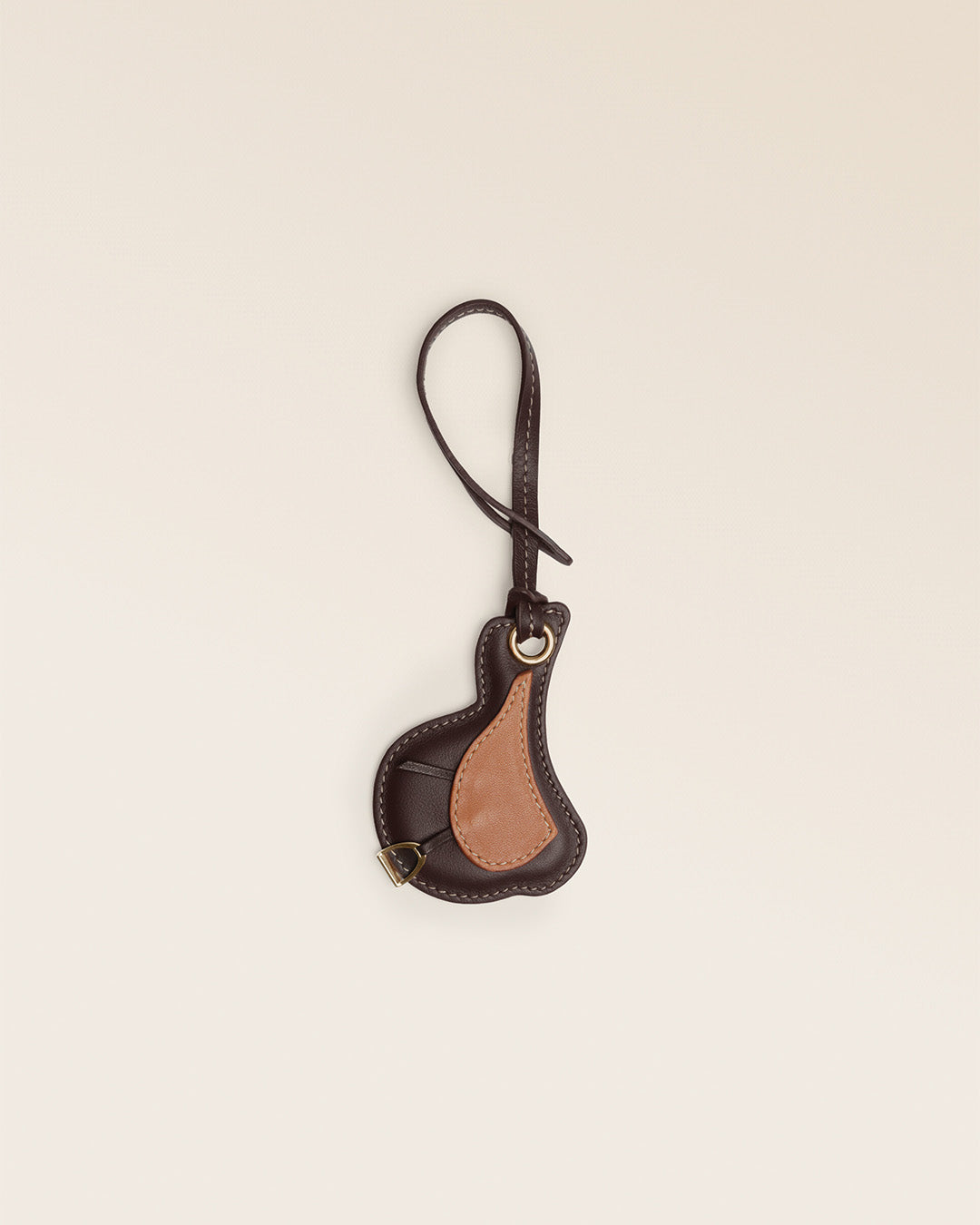 Le bijou de sac Selle Renouard en cuir lisse ébène et cuir lisse camel, vu de face en studio.