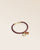 Le bracelet Jumping Renouard en cuir d'agneau lisse bordeaux et son pompon camel, vu de quart en studio.