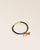 Le bracelet Jumping Renouard en cuir d'agneau lisse chocolat et son pompon orange, vu de quart en studio.
