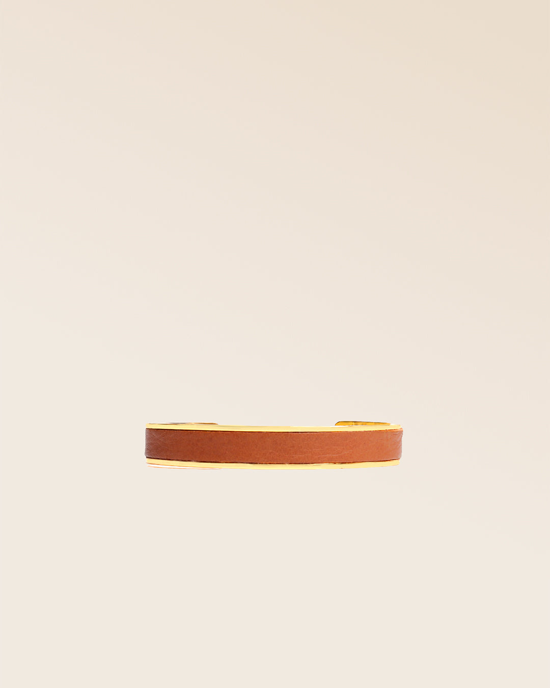Le bracelet Pacôme Renouard doré et cuir lisse camel, vu de face en studio.