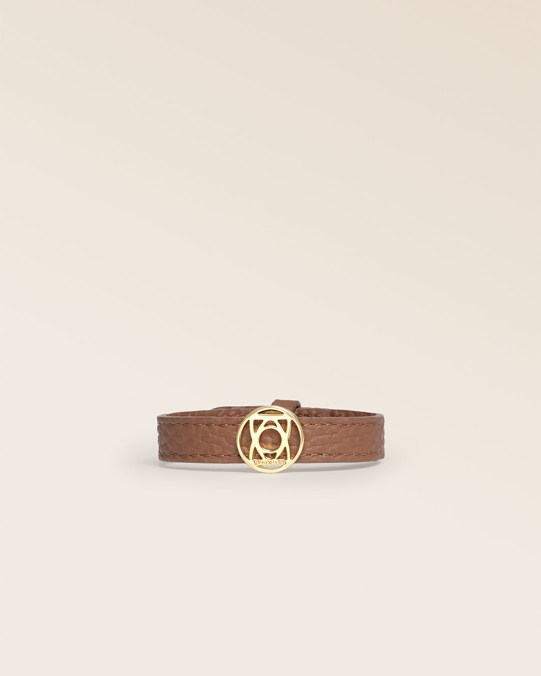 Le bracelet Alezan Renouard en cuir façon vigogne fauve et accessoire doré, vu de face en studio.