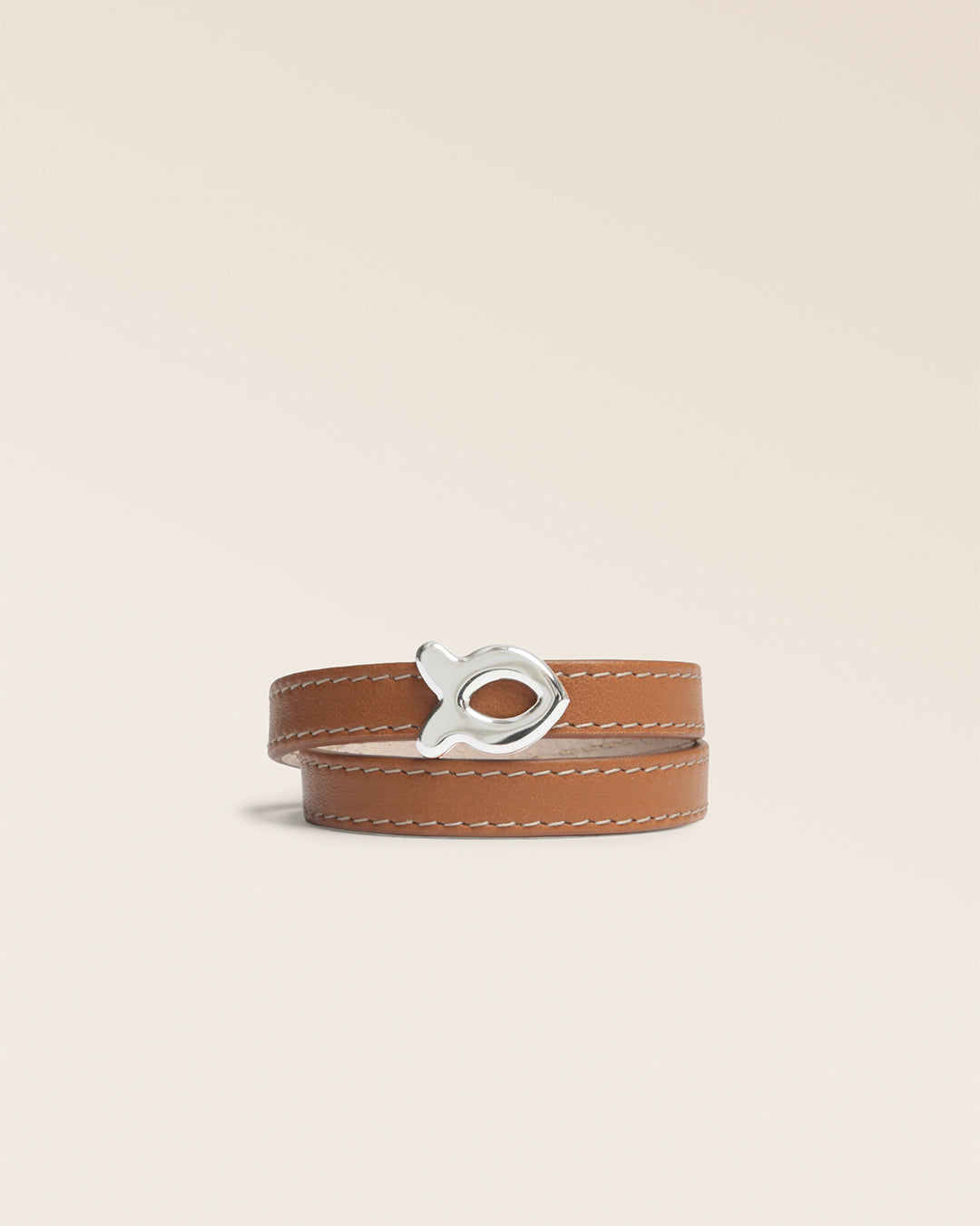 Le bracelet Sardine Renouard en cuir lisse camel et son accessoire poisson nickelé, vu de face en studio.