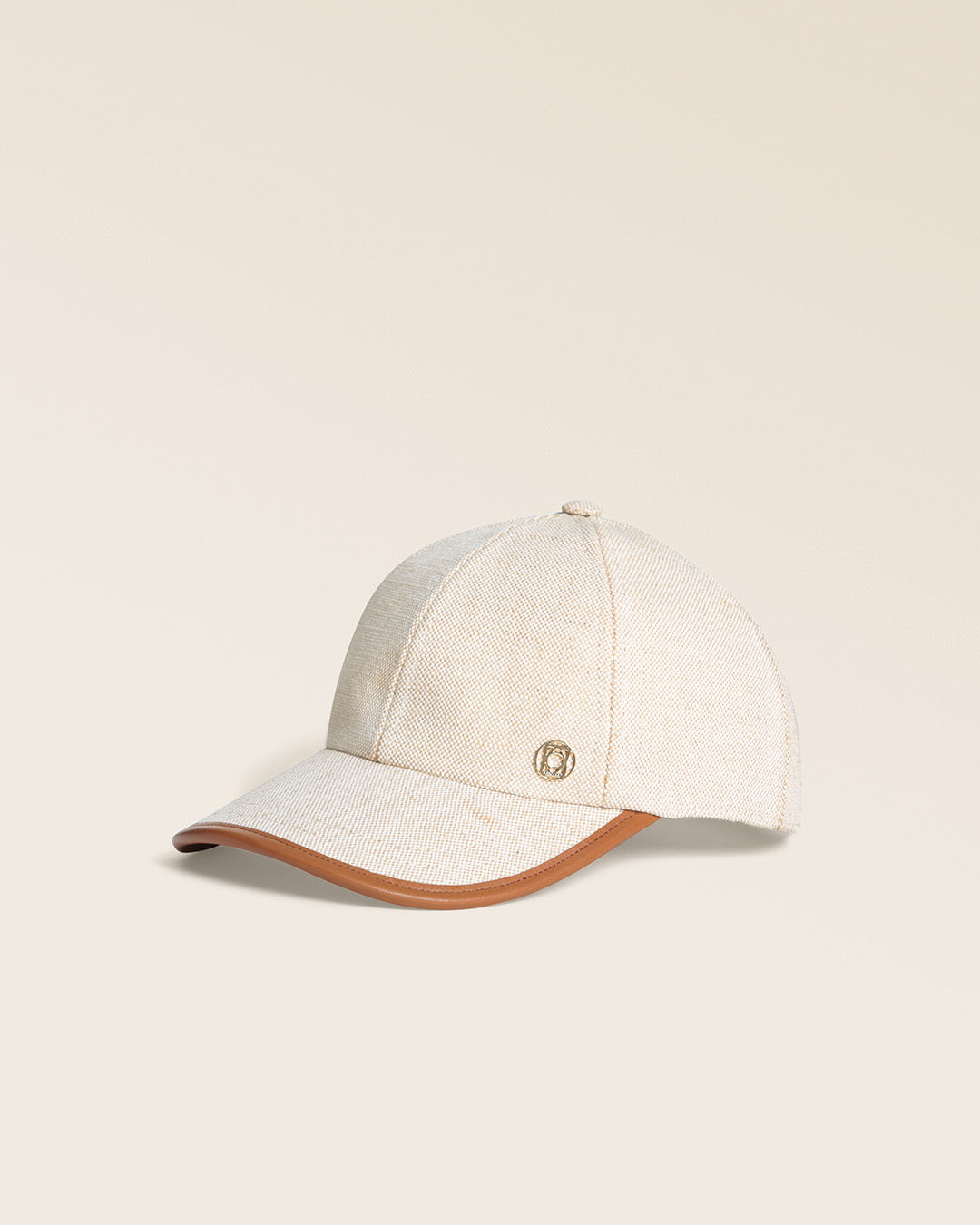Notre casquette Alba Renouard en toile de coton et cuir camel, vue de quart en studio.