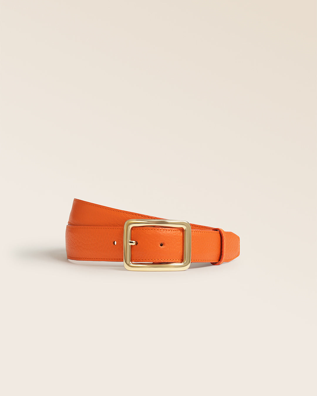 Notre ceinture Ariane Renouard en cuir façon vigogne orange, vue de face en studio.