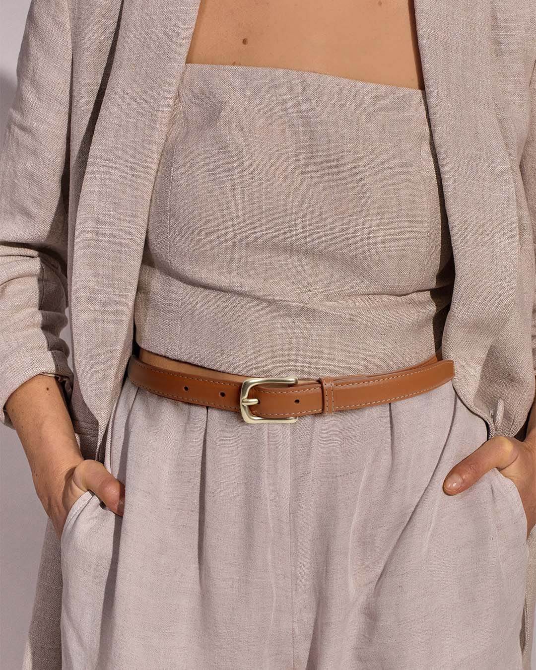 Notre ceinture Célia Renouard, en cuir vintage camel, vue portée par notre mannequin.