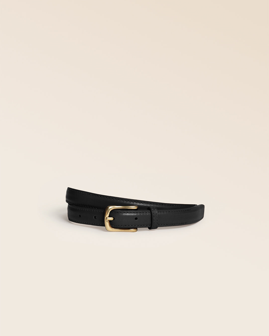 La ceinture Célia Renouard, en cuir lisse noir et boucle laiton vieilli, vue de face en studio.