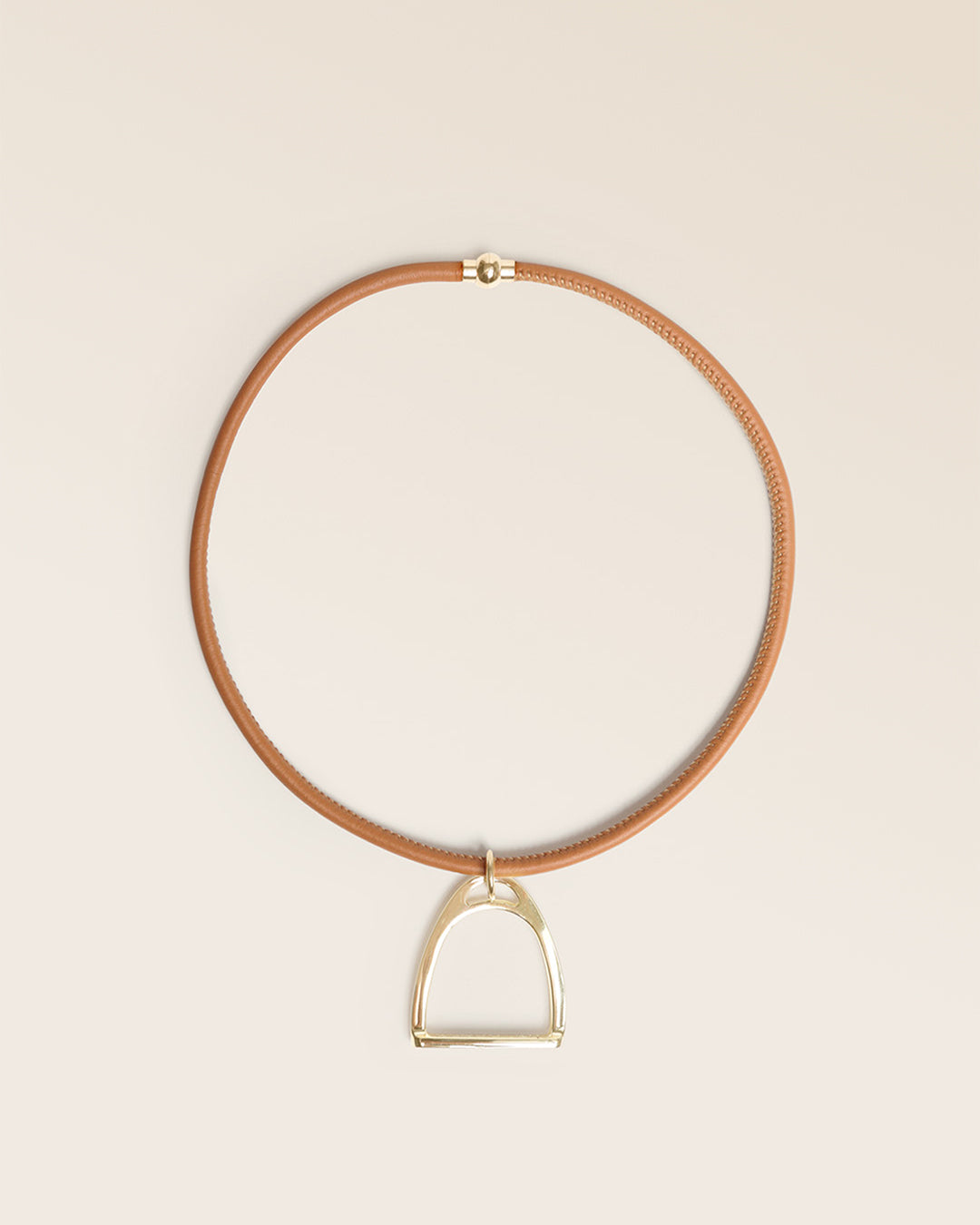 Notre collier Attelage Renouard, en cuir d'agneau camel et accessoire doré, vu de face en studio.