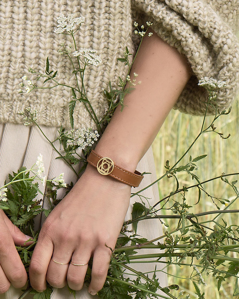Le bracelet Alezan Renouard en cuir lisse camel et son accessoire doré, vu porté par notre mannequin. 