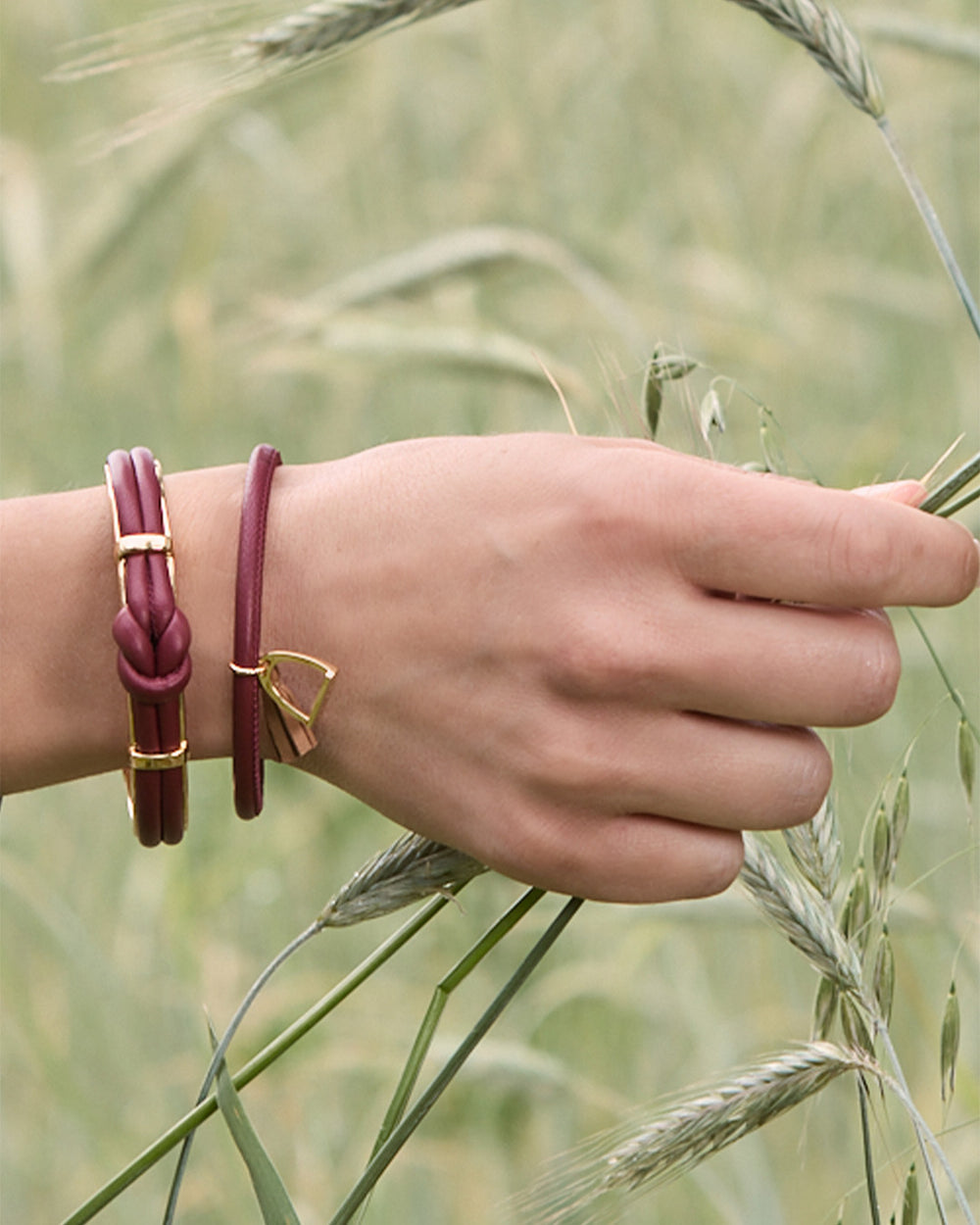 Le bracelet Jumping Renouard en cuir d'agneau bordeaux et pompon camel, vu porté par notre mannequin. 